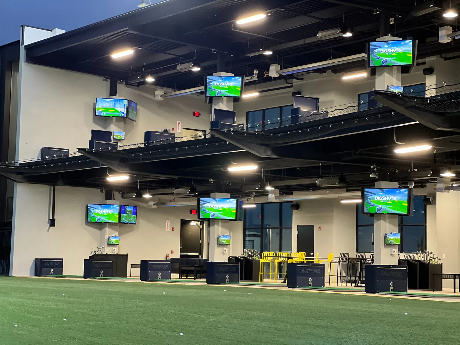 BigShots Golf bays with turf, displays, and seating