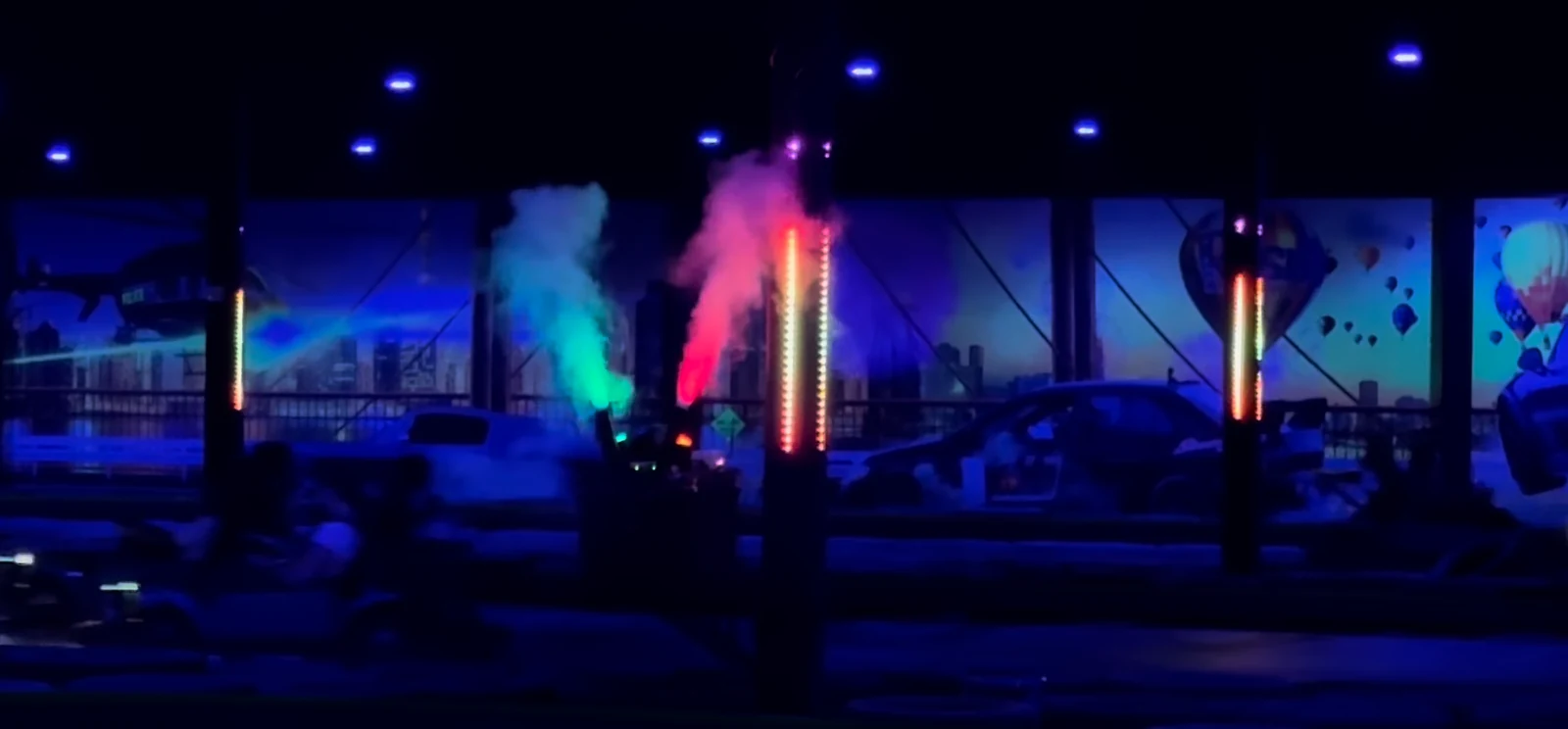 Go-karts racing through synchronized LED columns and colored fog